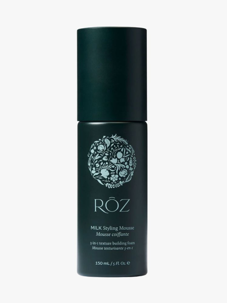 Dark blue bottle of Rōz Milk Styling Mousse on light gray background